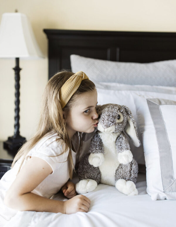 child kissing a plush bunny