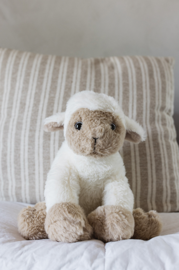 a plush lamb on with a pillow