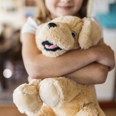 child hugging plush dog